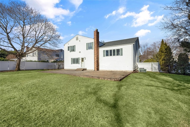 rear view of property with central AC unit, a yard, and a patio area