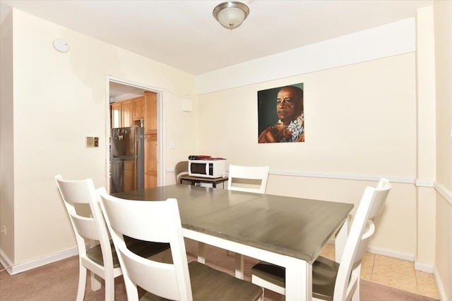 dining space with baseboards and light tile patterned floors