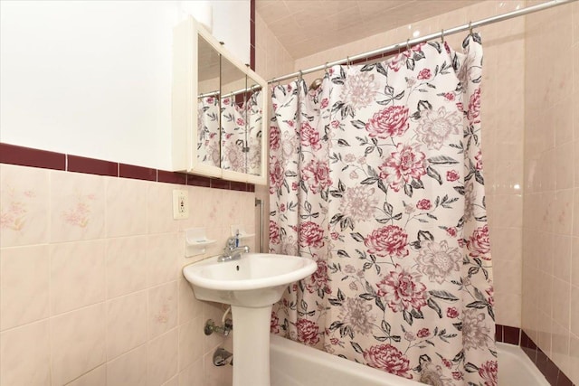 bathroom with tile walls and shower / tub combo with curtain