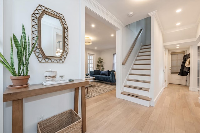 stairway with ornamental molding and hardwood / wood-style floors