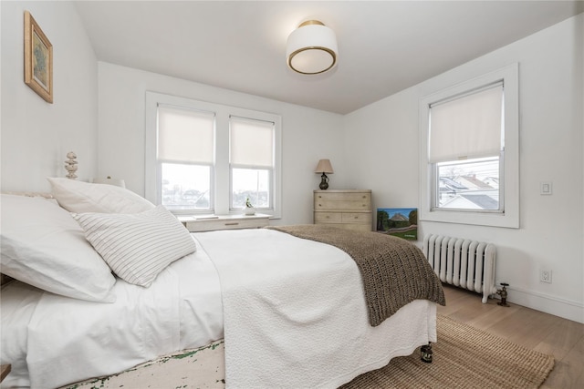 bedroom featuring radiator and hardwood / wood-style flooring