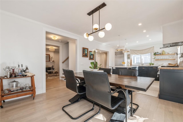 dining room featuring crown molding and light hardwood / wood-style floors