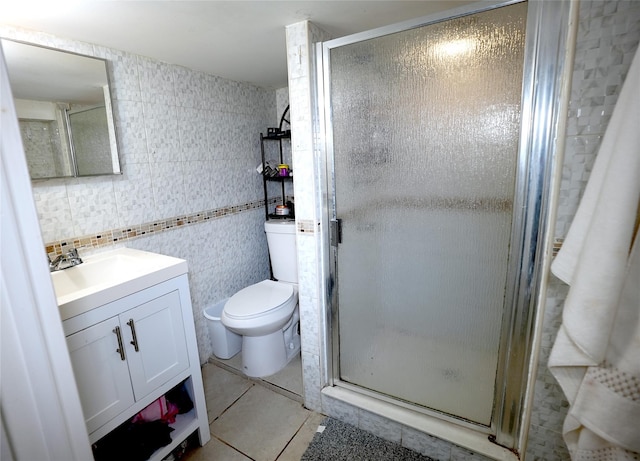 bathroom with tile walls, tile patterned flooring, vanity, an enclosed shower, and toilet