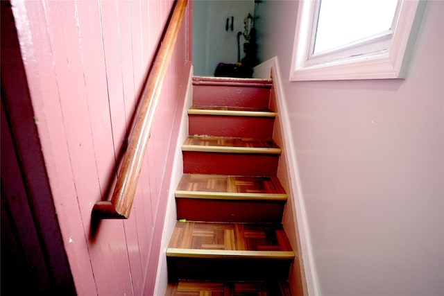 stairway featuring parquet flooring