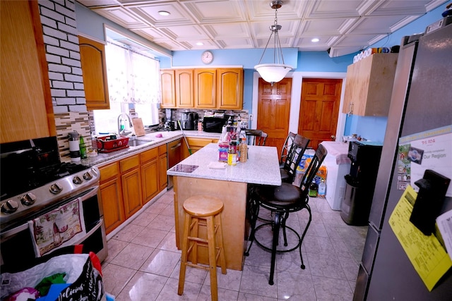 kitchen featuring a kitchen island, appliances with stainless steel finishes, decorative light fixtures, tasteful backsplash, and sink