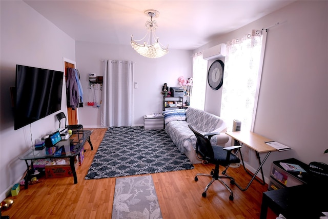 living room featuring a wall mounted air conditioner, hardwood / wood-style flooring, plenty of natural light, and a chandelier