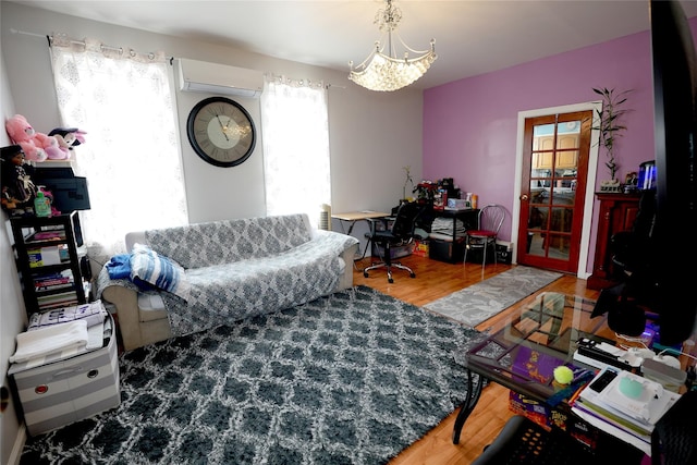 living room with a chandelier, wood-type flooring, and a wall mounted AC