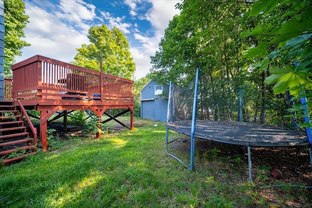 view of yard with a wooden deck and a trampoline