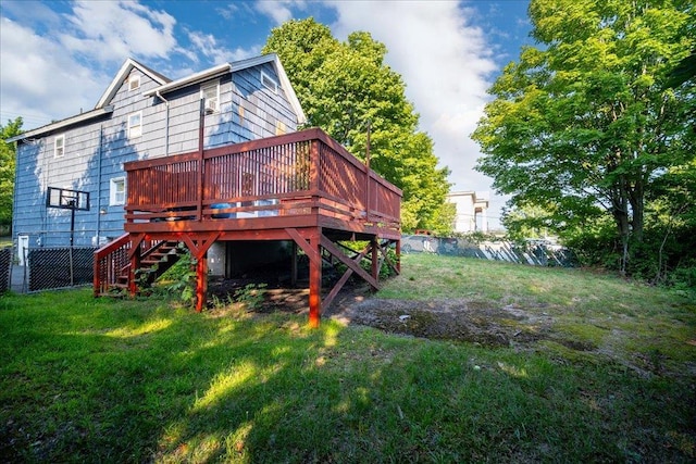 back of house featuring a deck and a lawn