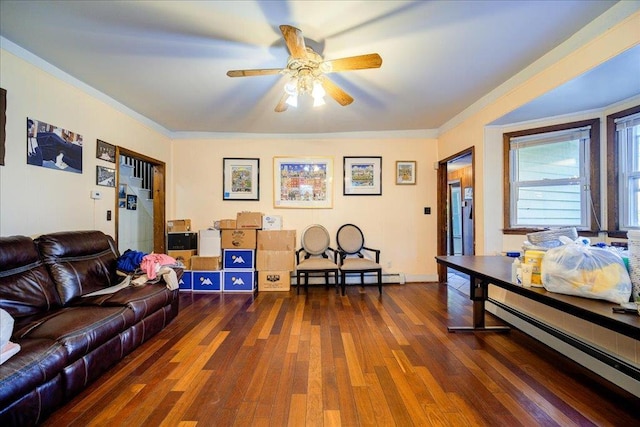 living room with crown molding, ceiling fan, dark hardwood / wood-style floors, and a baseboard heating unit