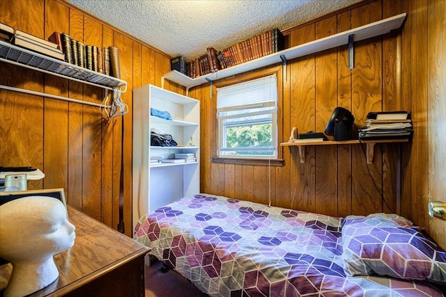 bedroom with wooden walls, a closet, and a textured ceiling