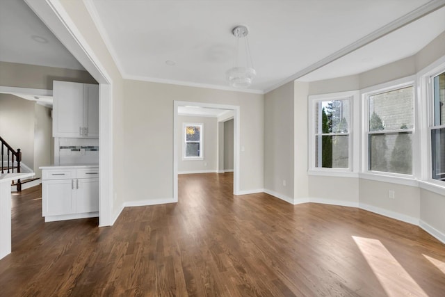 unfurnished dining area with an inviting chandelier, ornamental molding, and dark hardwood / wood-style flooring