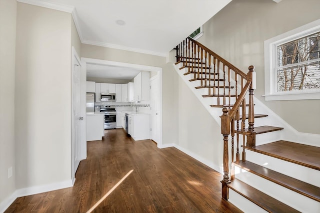 stairway featuring crown molding and hardwood / wood-style flooring