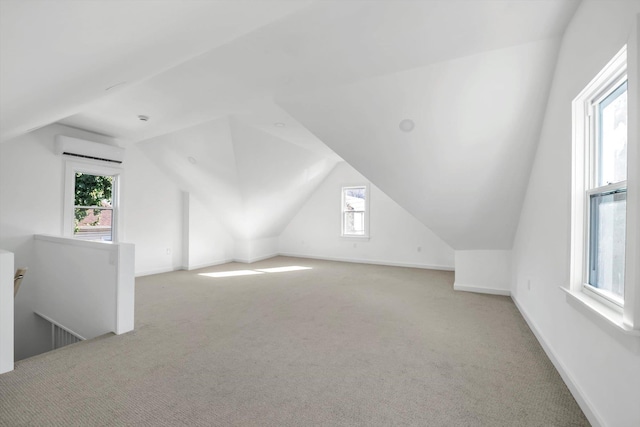 bonus room featuring light colored carpet, lofted ceiling, and a wall mounted AC