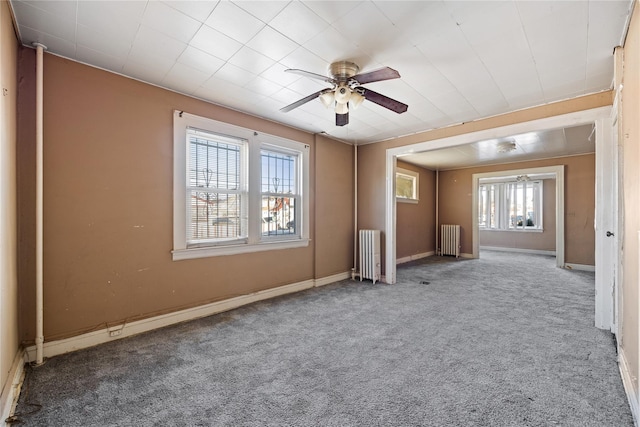 carpeted spare room with radiator heating unit and ceiling fan