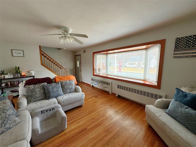 living room with ceiling fan, radiator heating unit, and light hardwood / wood-style floors