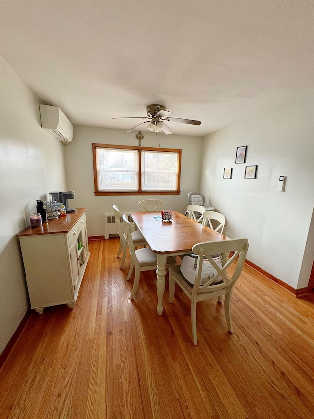 dining space featuring ceiling fan, a wall mounted air conditioner, light hardwood / wood-style floors, and radiator heating unit