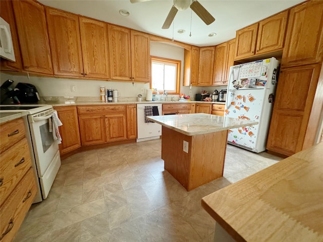 kitchen with white appliances, a center island, and ceiling fan