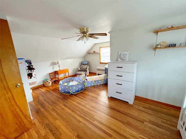 interior space with lofted ceiling, radiator, ceiling fan, and light wood-type flooring