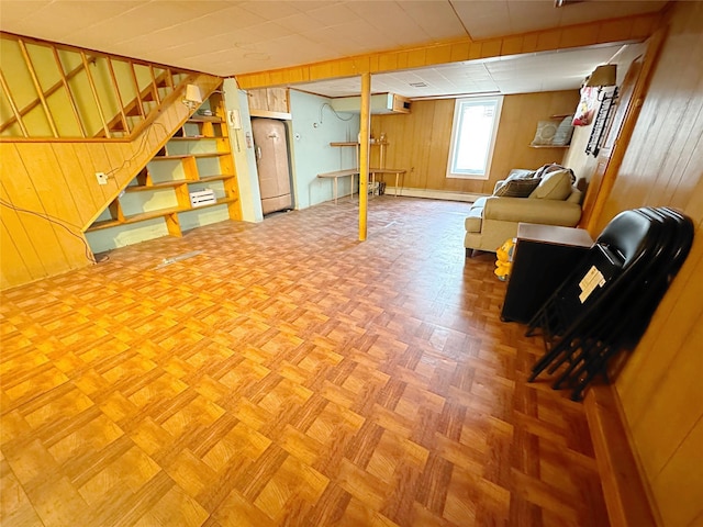 basement featuring parquet floors and wooden walls