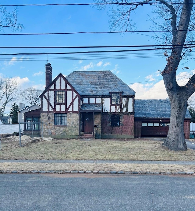 tudor home featuring a front lawn