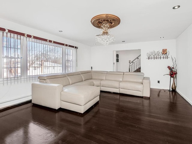 living room with a baseboard heating unit, dark hardwood / wood-style floors, and an inviting chandelier