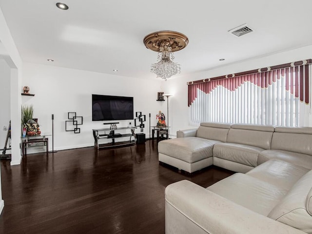 living room with dark wood-type flooring and an inviting chandelier