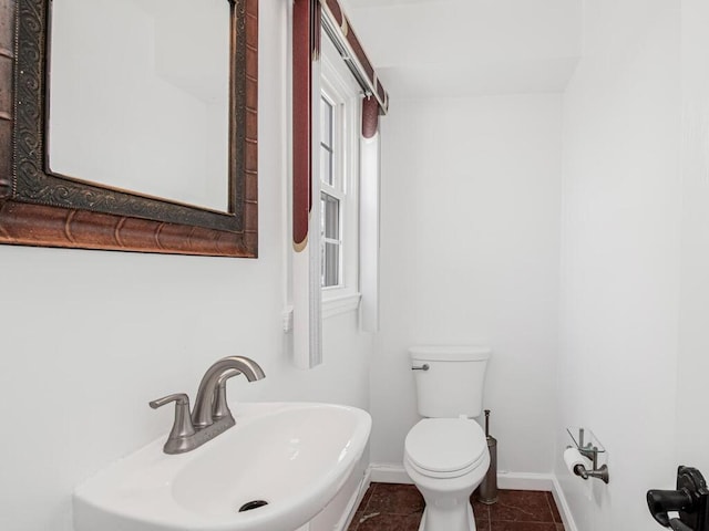 bathroom featuring toilet, tile patterned flooring, and sink