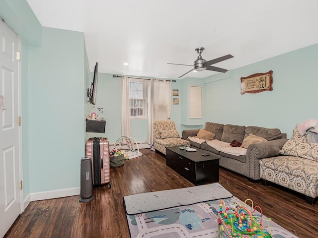 living room featuring baseboard heating, ceiling fan, and dark hardwood / wood-style floors