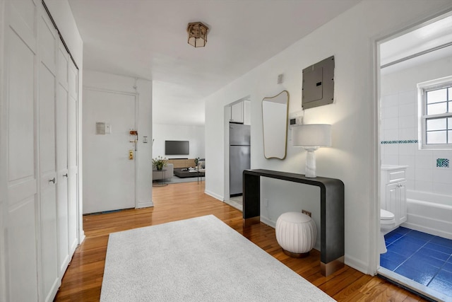 corridor featuring wood-type flooring and electric panel