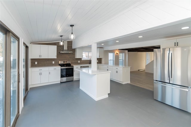 kitchen featuring pendant lighting, white cabinetry, stainless steel appliances, kitchen peninsula, and wall chimney exhaust hood