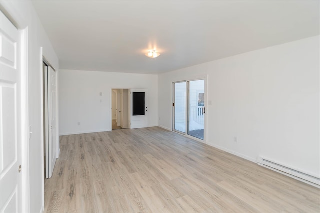 spare room with a baseboard radiator and light wood-type flooring