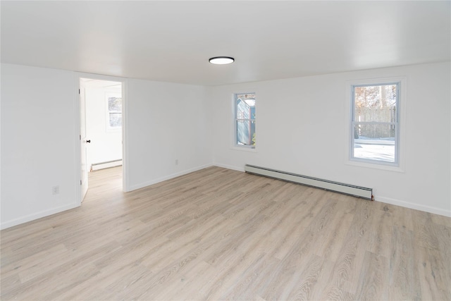 unfurnished room featuring a baseboard radiator and light hardwood / wood-style floors