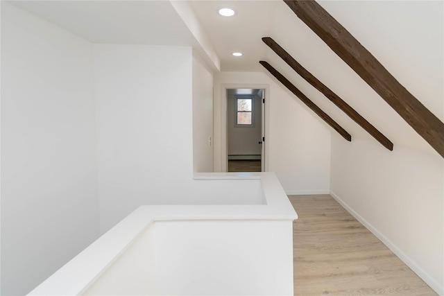 staircase with hardwood / wood-style floors, vaulted ceiling, and baseboard heating