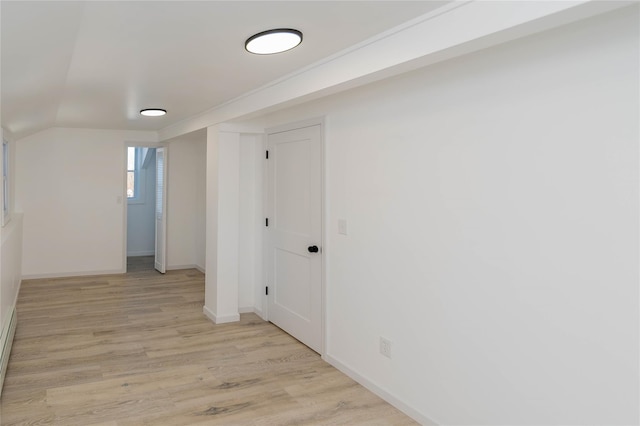 corridor featuring lofted ceiling and light hardwood / wood-style flooring