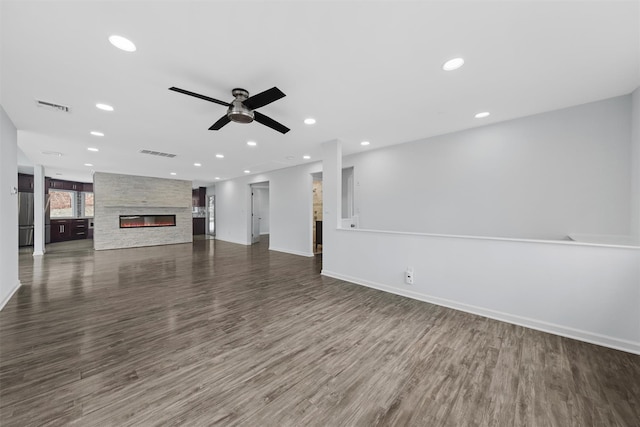 unfurnished living room with dark hardwood / wood-style floors, ceiling fan, and a fireplace