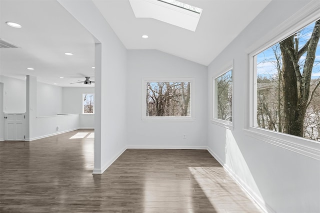 empty room featuring vaulted ceiling with skylight and dark hardwood / wood-style flooring