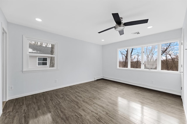 spare room featuring dark hardwood / wood-style flooring, a baseboard radiator, and ceiling fan