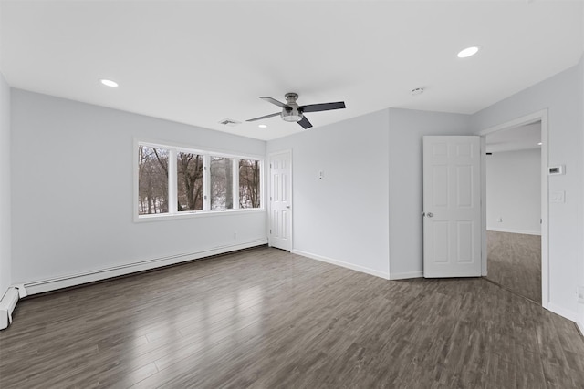 spare room with ceiling fan, dark hardwood / wood-style floors, and a baseboard heating unit