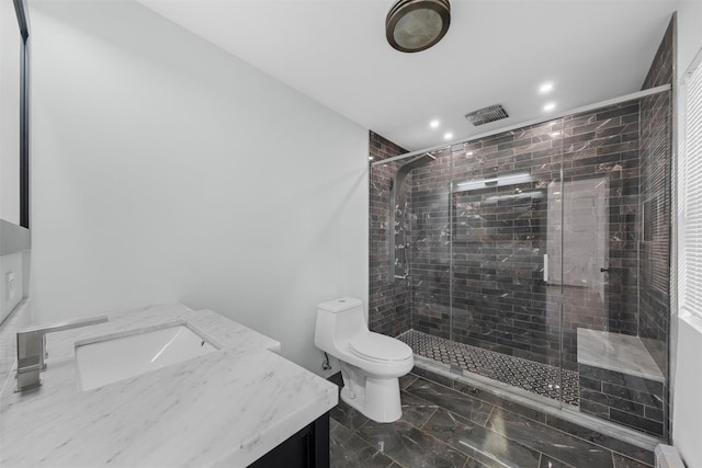 bathroom featuring a shower with door, vanity, baseboard heating, and toilet