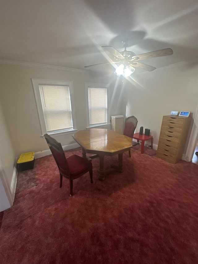 dining space featuring crown molding, ceiling fan, and dark carpet