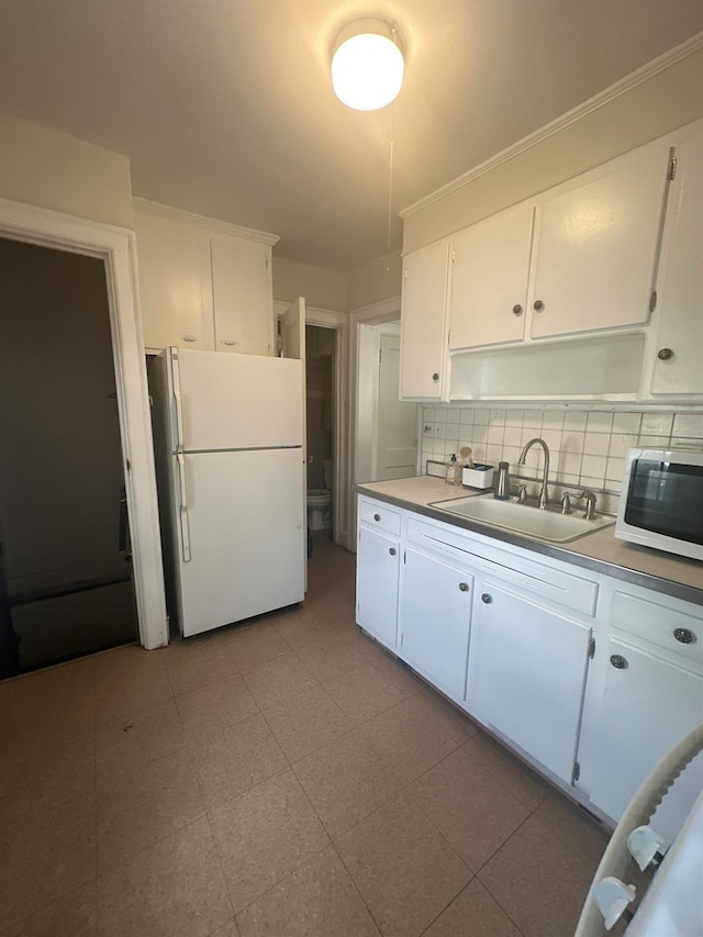 kitchen featuring sink, white appliances, decorative backsplash, and white cabinets