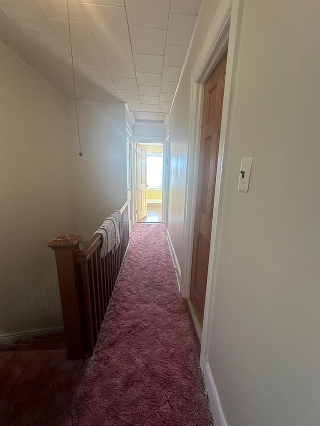 hallway with dark colored carpet