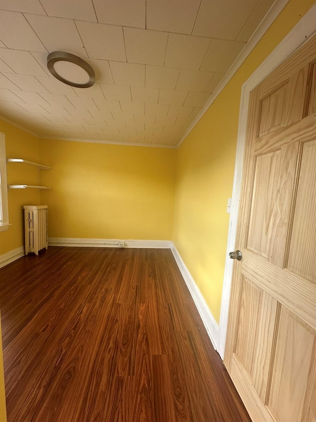 empty room featuring crown molding and dark hardwood / wood-style floors