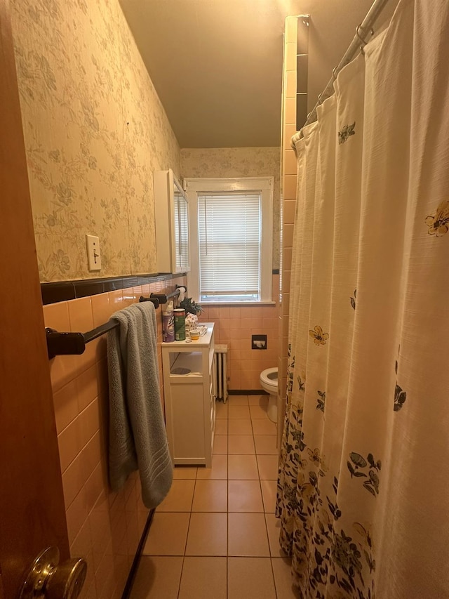 bathroom with radiator, tile patterned flooring, tile walls, vanity, and toilet