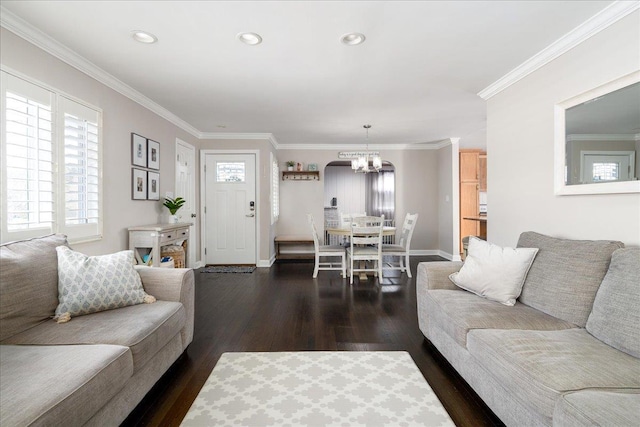 living room with ornamental molding, dark hardwood / wood-style floors, and a notable chandelier