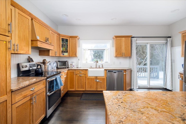 kitchen featuring light stone counters, appliances with stainless steel finishes, dark hardwood / wood-style floors, and sink