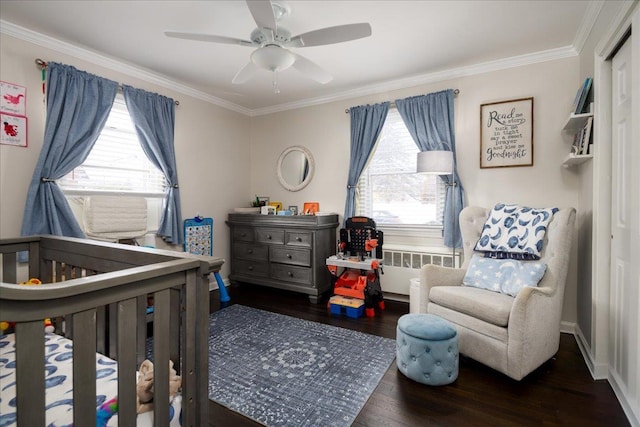 bedroom featuring crown molding, radiator heating unit, dark hardwood / wood-style floors, and multiple windows