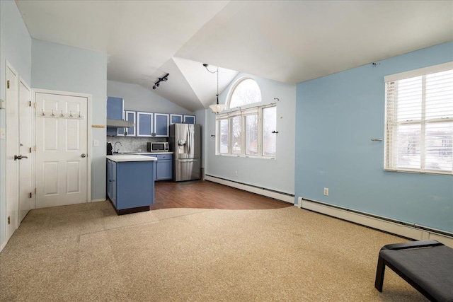 kitchen with lofted ceiling, a baseboard heating unit, stainless steel appliances, blue cabinets, and decorative light fixtures