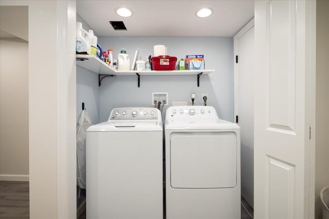 clothes washing area with hardwood / wood-style flooring and washer and clothes dryer